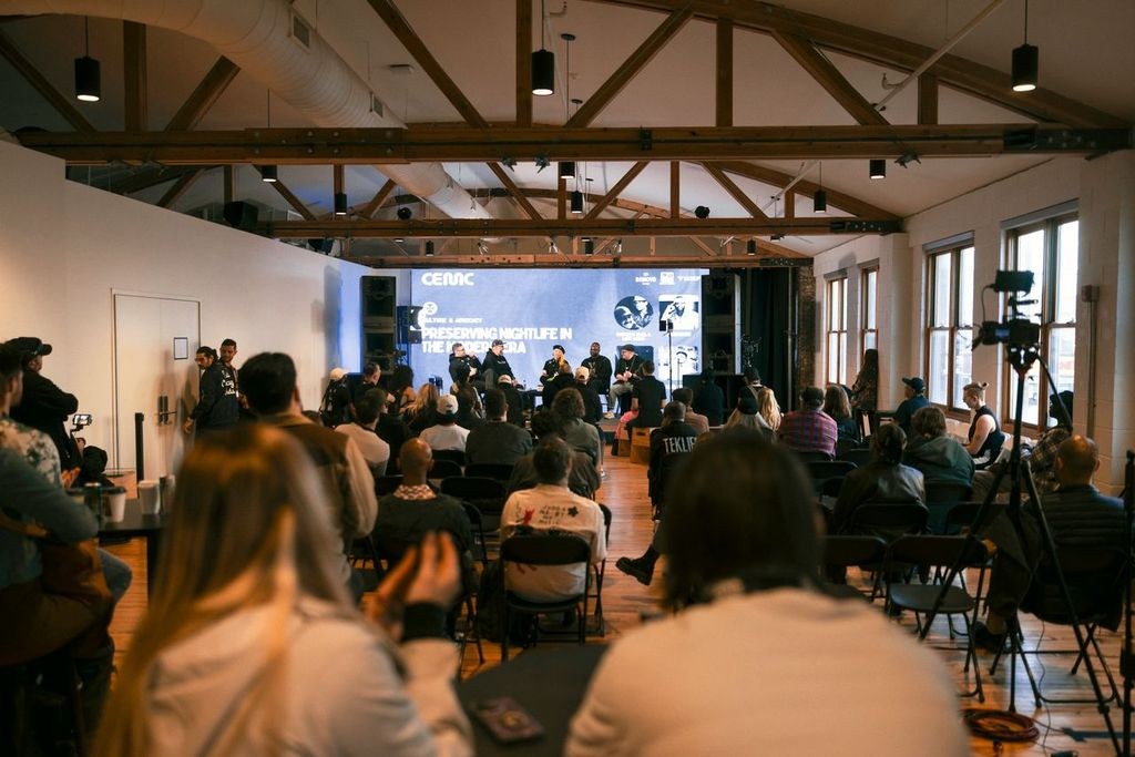 Audience attending a professional panel discussion in a live event venue