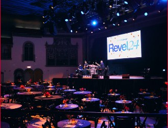 Theatre set for a formal event with tables and stage lighting