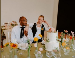 Couple celebrating beside a wedding cake at a private event